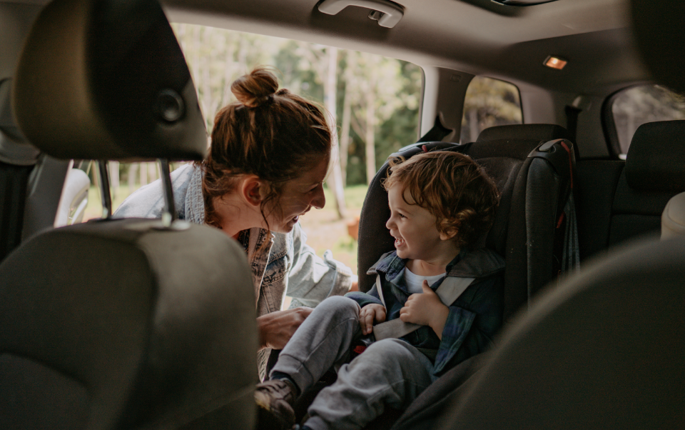 woman getting a child into a carseat