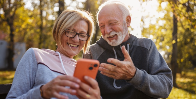 Cheerful seniors in sports clothing sitting on a park bench afte