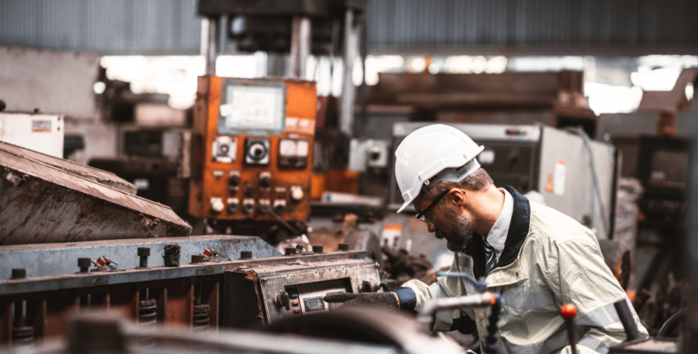 Engineer working at industrial machinery in factory. Manual workers cooperating while measuring a electronic.