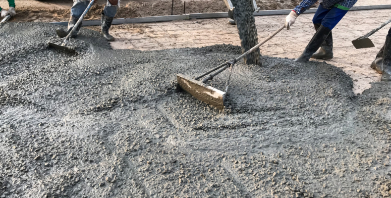 Workers pouring reinforced concrete floors on site